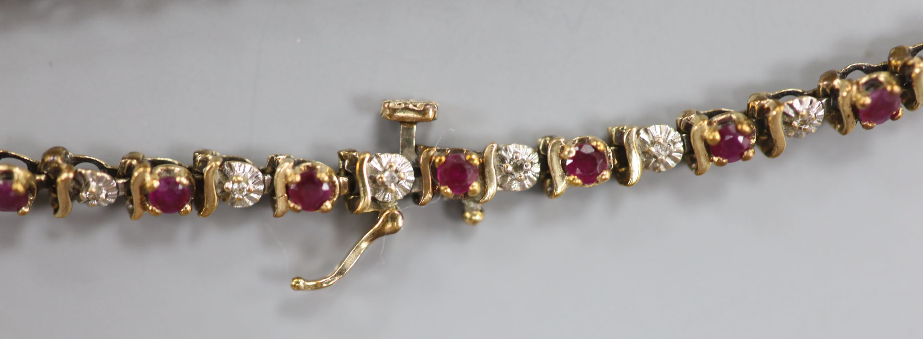 A modern 9ct gold, ruby and diamond chip set line bracelet, 20.3cm, gross 7.5 grams.